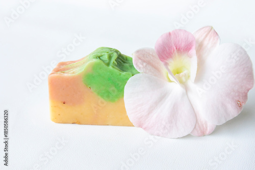 Handmade soap bar with pink orchid flower isolated on white background. Close up and front view