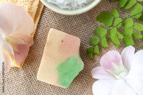 Handmade soap on burlap with orchid flower, towel and bath salt, Concept of sustainable use, bath products. Flat lay