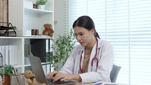 Young female doctor standing at desk and using digital tablet in office. General practitioner family doctor gynecologist checking on diagnosis, sending test results online.