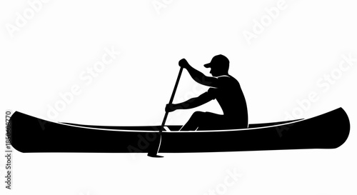 Silhouette of a person paddling a canoe on the water.