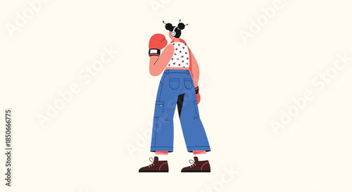 Rear view of a woman with dark hair buns wearing boxing gloves blue cargo pants and a floral top ready for a workout against beige background.