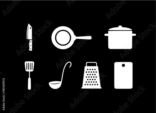 A set of kitchen utensils and tools arranged against a black background