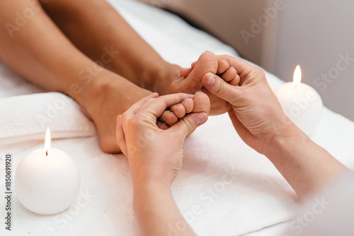 Woman enjoyingreflexology foot massage in wellness spa
