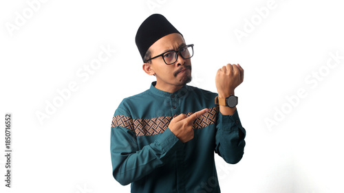 Tableau sur toile Impatient young Asian Muslim man pointing at his wristwatch while waiting for iftar, the time to break fasting during Ramadan