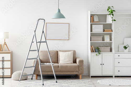 Fotografie Interior of living room with stepladder, sofa and blank frame