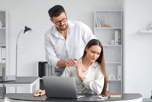 Quadro su tela Businessman molesting his female colleague at desk in office