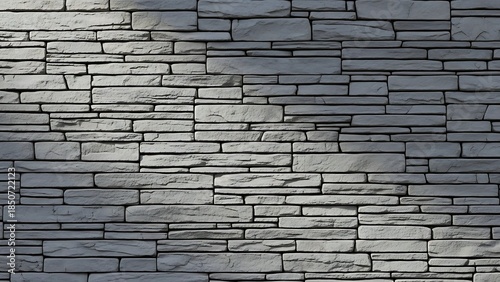 Close-up of a gray stone wall with a white background and a shallow depth of field, showcasing stacked slate tiles.