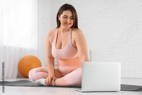 Sporty plus size woman usin...