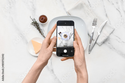 Quadro em tela Female photographer with mobile phone taking picture of tasty pasta on marble ba