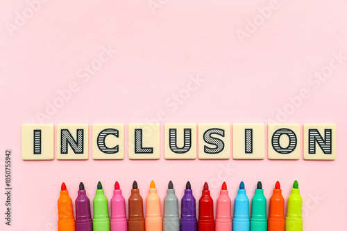 Photos Word INCLUSION with felt-tip pens on pink background