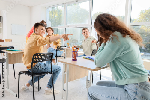 Classmates laughing at teen...