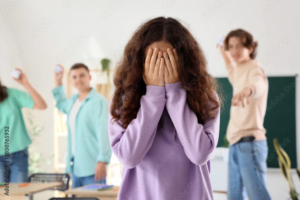 Fototapeta premium Bullied teenage girl crying in classroom