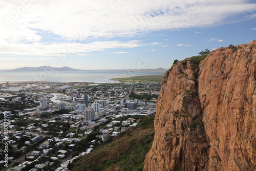 Urban environmental scene atop Castle Hill in Townsville, with Magnetic Island on the horizon with developing storm clouds shrouding the island