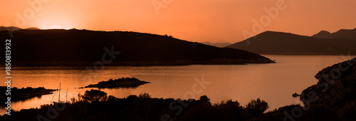 Sunset over the Peloponesse mountains viewed from the Poros island in warm colours