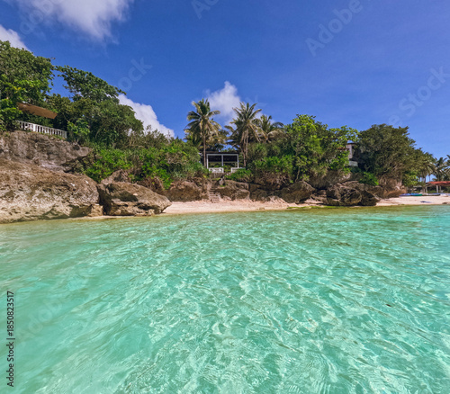 Tropical beach with crystal blue waters in Anda, Bohol with palms and rocks, Anda, Bohol island, Philippines