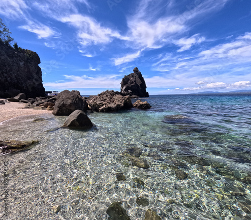 Rocky beach with crystal blue waters in Apo Island, Negros, Philippines