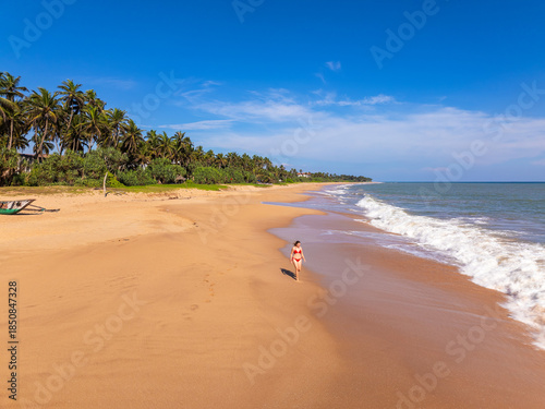 Aerial View of a Young Woman Walking on Orange Sand Beach at Kahandamodara, Southern Sri Lanka