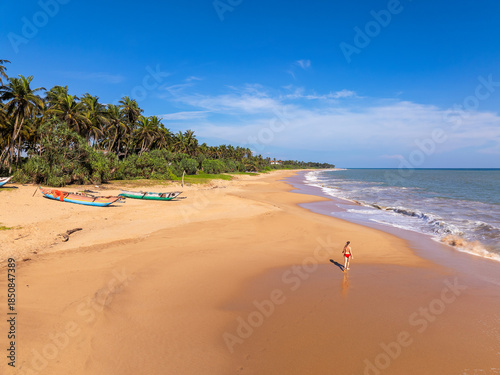 Aerial View of a Young Woman Walking on Orange Sand Beach at Kahandamodara, Southern Sri Lanka