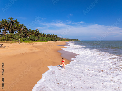 Aerial View of a Young Woman Walking on Orange Sand Beach at Kahandamodara, Southern Sri Lanka