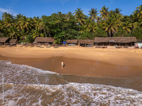 Young Woman Walking on Golden Sand Beach with Thatched Beach Huts, Goyambokka Beach, Sri Lanka