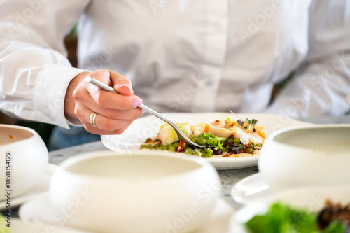 Fotografie A close-up shot of a person in a white shirt enjoying a healthy, colorful meal o
