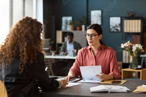 Εκτύπωση καμβά Caucasian woman wearing glasses discussing documents with young adult woman acro