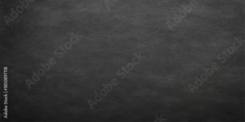 A dark grunge texture of an old black chalkboard background with a rough grey wall pattern and vintage dirty blackboard surface design