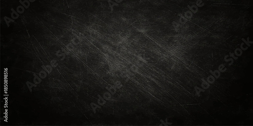 A dark and empty black grunge background featuring a weathered chalkboard texture with a rough gray vintage surface and a dirty paper wallpaper pattern for a blank frame design