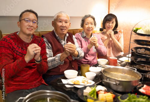 Happy Asian family celebrating Chinese New Year in restaurant