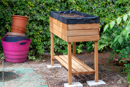 Wooden raised garden bed filled with soil outdoors
