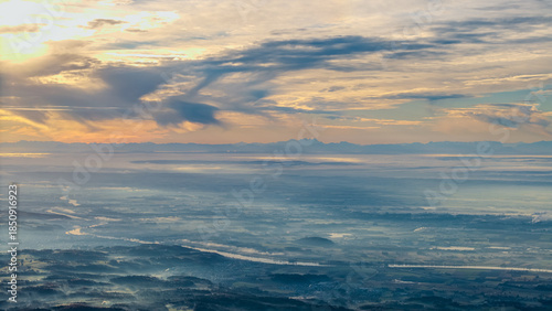 Sonnenuntergang über der Landschaft mit Wolken und Fluss im Vordergrund