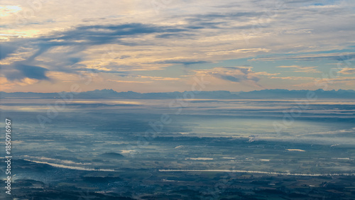 Großer Blick auf Wasser und Himmel mit Wolken am Horizont über den Ostalpen während des Tages