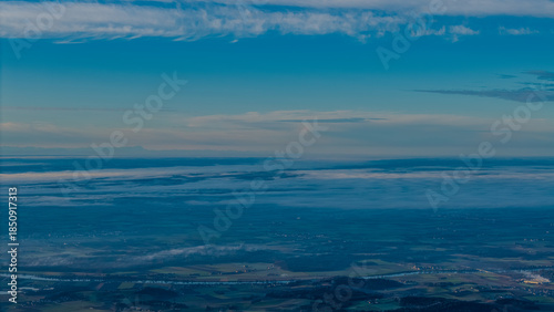 Blick auf die Landschaft von oben mit offenem Himmel und Wolken in der Dämmerung