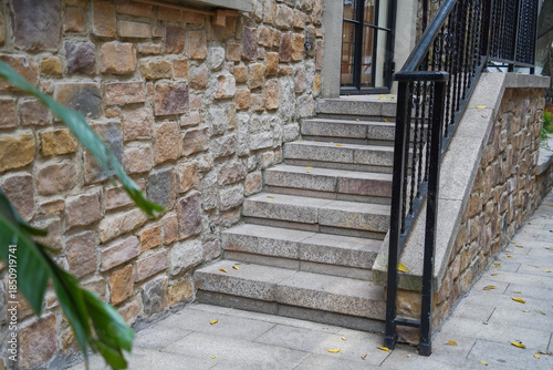 Black wrought iron railing near staircase on tile porch of private home.
