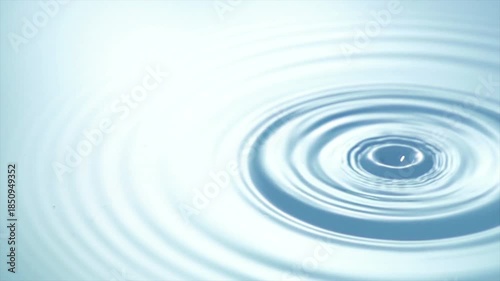 Slow motion water drop splash creating smooth ripples on calm surface with minimal clean background symbolizing purity, freshness, balance and relaxation