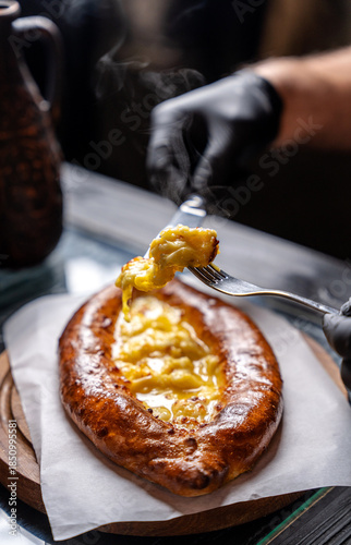 Bild auf Leinwand Georgian khachapuri being eaten with fork