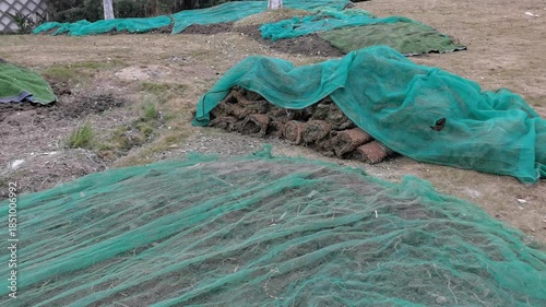 Damaged Lawn with Soil Cover Net, Dust Control Net & Piled Turf Waiting for Restoration