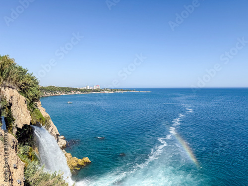 Stunning View of Lower Duden Waterfall Plunging Directly into the Mediterranean Sea with a Small Rainbow and the Antalya Skyline