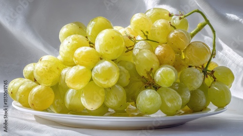 A bright and fresh arrangement of white-backed grapes placed on a white plate, with soft light illuminating their translucent skin and highlighting their beauty