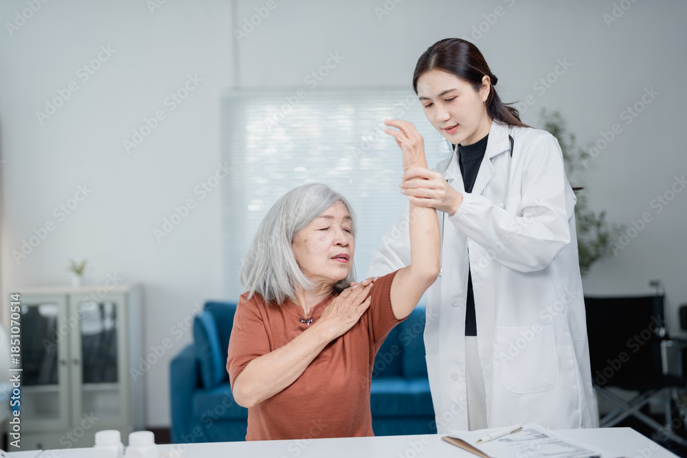 Fototapeta premium Doctor assisting senior woman with arm physical therapy