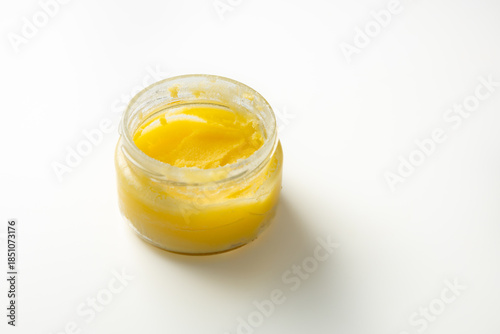 Close up of melted dairy butter ghee in jar light surface