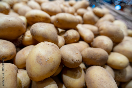 Fresh organic potatoes piled on a market stall ready for sale