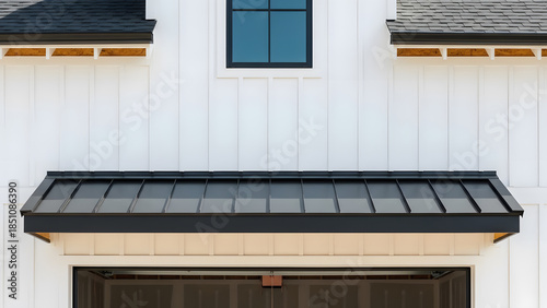 Modern farmhouse exterior white board and batten siding | Black standing seam metal awning over garage door opening | Architectural detail of white house facade and black roof elements 