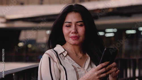 Businesswoman using a smartphone checking media social, ordering food via mobile app online while standing relaxed in the office outdoor corporate building.