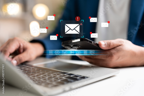 A Businessman working on a laptop, mobile phone open an email caution warning sign for notification error and maintenance concept, network security, computer virus detected, personal data protection.