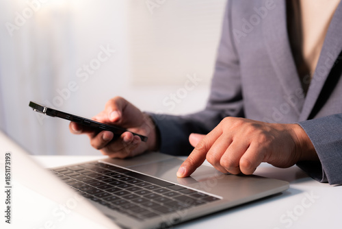 Close-up of hands man using laptop computer with mobile phone on office desk. Workspace, businessman working project creative idea for job online network. Business finance and technology concept.