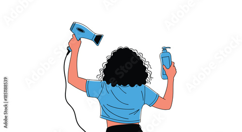 View from behind of a woman with curly hair holding a blue hair dryer in one hand and a bottle of shampoo or lotion in the other.