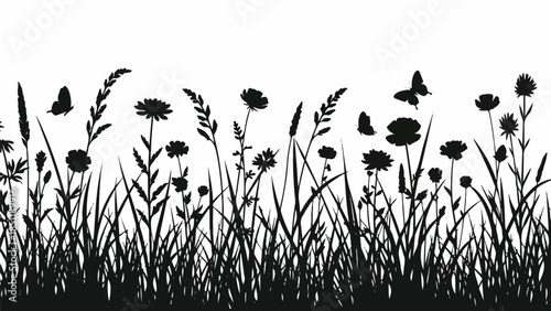 Silhouetted flowers and grass swaying gently in the breeze on a serene meadow landscape viewed from a low angle