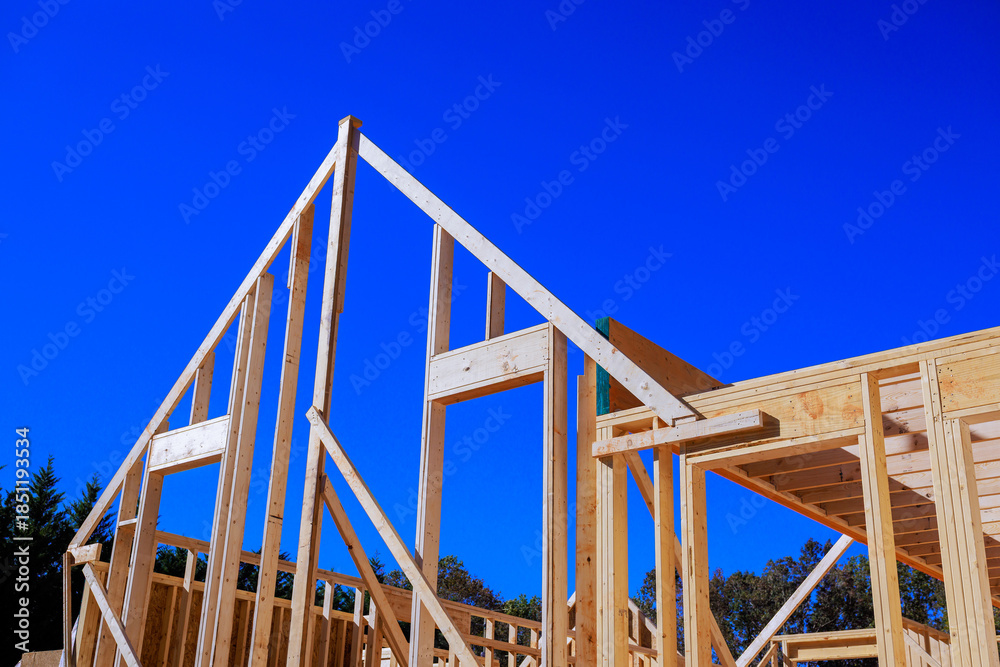 Obraz premium Workers build framework rafters beams of wooden house in construction site.