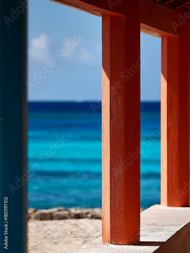 Wooden pillars surround the deep blue ocean, bathed in the bright midday sun